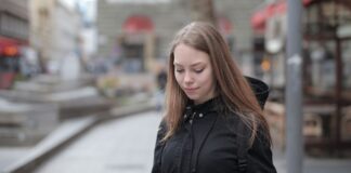 Młoda kobieta korzysta z tabletu na miejskiej ulicy z publicznym Wi‑Fi