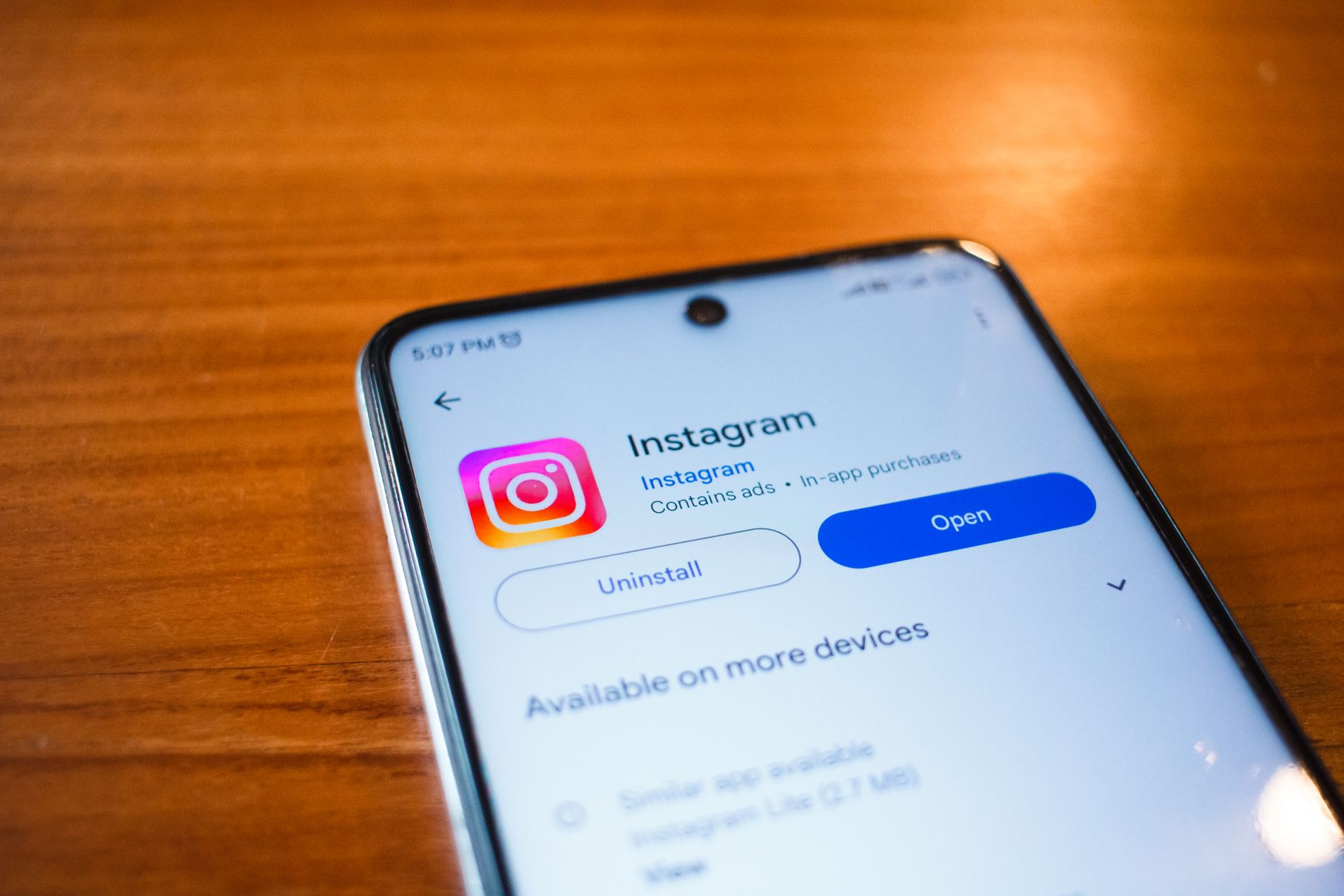 Smartfon z otwartą aplikacją Instagram leżący na drewnianym stole