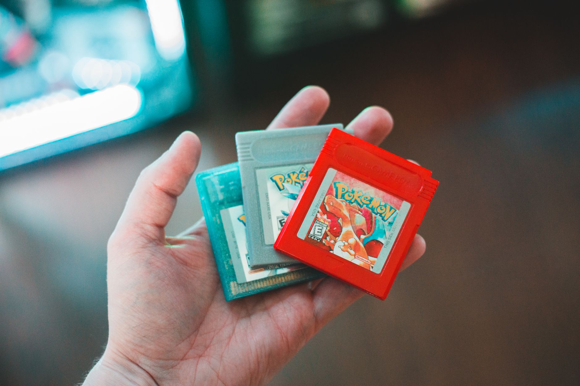 Dłoń trzymająca retro kartridże gier Pokemon