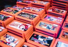 Stos retro kartridży gier w pomarańczowych pudełkach z popularnymi tytułami