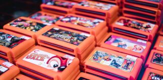 Stos retro kartridży gier w pomarańczowych pudełkach z popularnymi tytułami