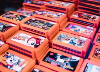 Stos retro kartridży gier w pomarańczowych pudełkach z popularnymi tytułami