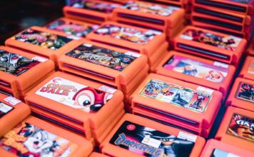 Stos retro kartridży gier w pomarańczowych pudełkach z popularnymi tytułami