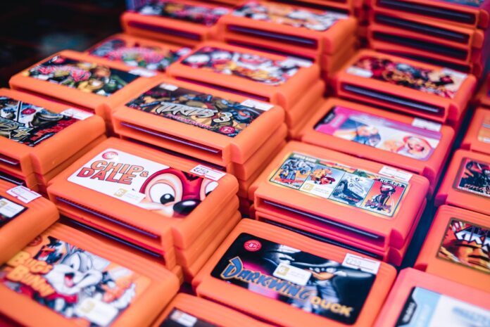 Stos retro kartridży gier w pomarańczowych pudełkach z popularnymi tytułami