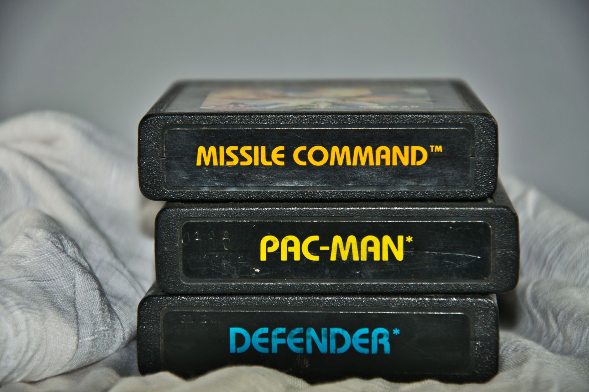 Zbliżenie na kartridże gier Atari: Missile Command, Pac‑Man i Defender