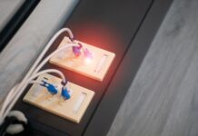 Zbliżenie portów Ethernet z podłączonymi kablami i świecącymi diodami