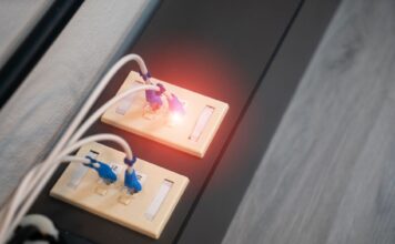 Zbliżenie portów Ethernet z podłączonymi kablami i świecącymi diodami