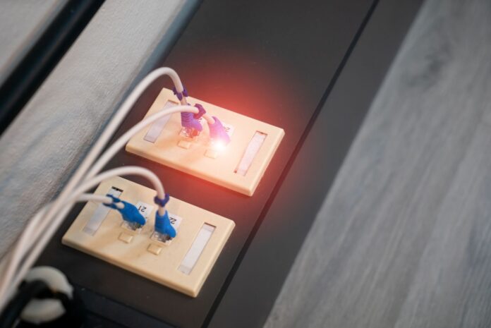 Zbliżenie portów Ethernet z podłączonymi kablami i świecącymi diodami